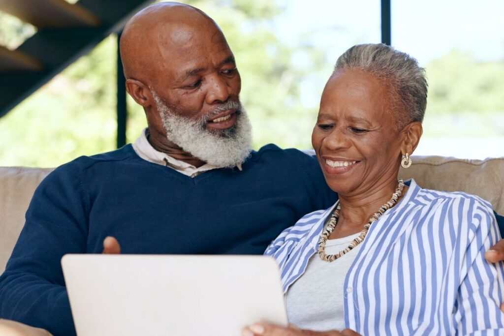 Older couple reviewing information together on a tablet while planning ahead for senior living.